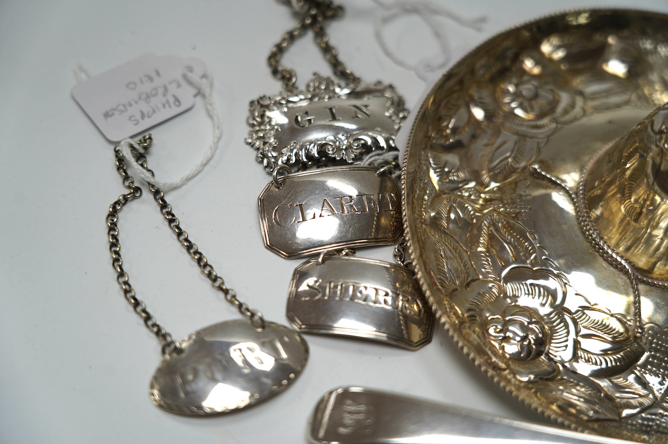 Four assorted 19th century silver wine labels, including a pair 'Sherry & Claret' by Joseph Wilmore, Birmingham, 1810, a Mexican 925 hat, a George III sauce ladle, by Eley & Fearn, London, 1802, a pair of silver sugar ni